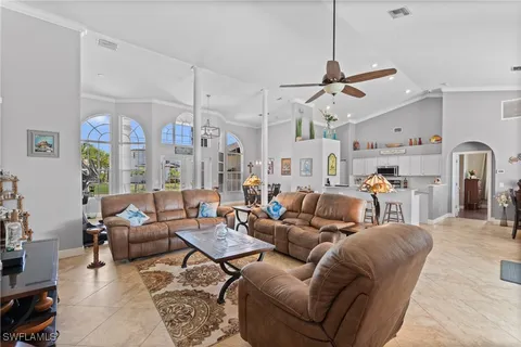 a living room with furniture kitchen view and a chandelier