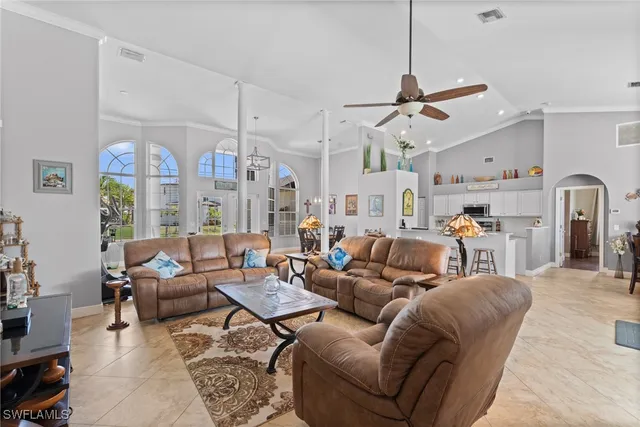 a living room with furniture kitchen view and a chandelier