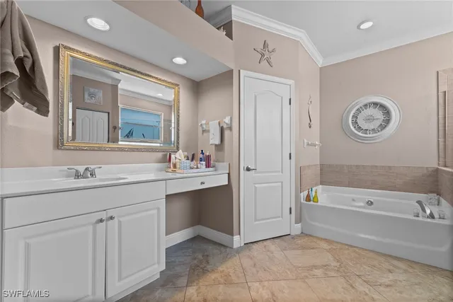 a bathroom with a tub a sink and a mirror