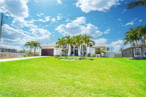 a view of a house with a big yard and a large tree