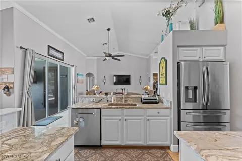 a kitchen with stainless steel appliances kitchen island granite countertop a refrigerator and a sink
