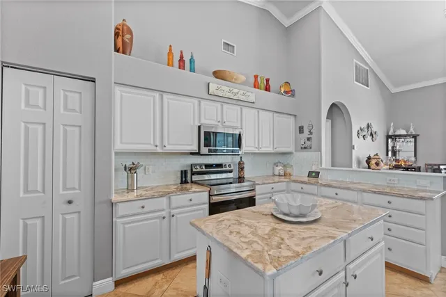 a kitchen with granite countertop white cabinets and white appliances