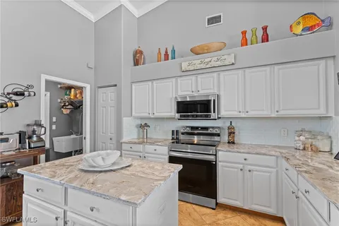 a kitchen with stainless steel appliances granite countertop a sink stove and cabinets
