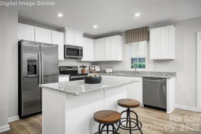 a kitchen with stainless steel appliances granite countertop a refrigerator stove microwave and sink