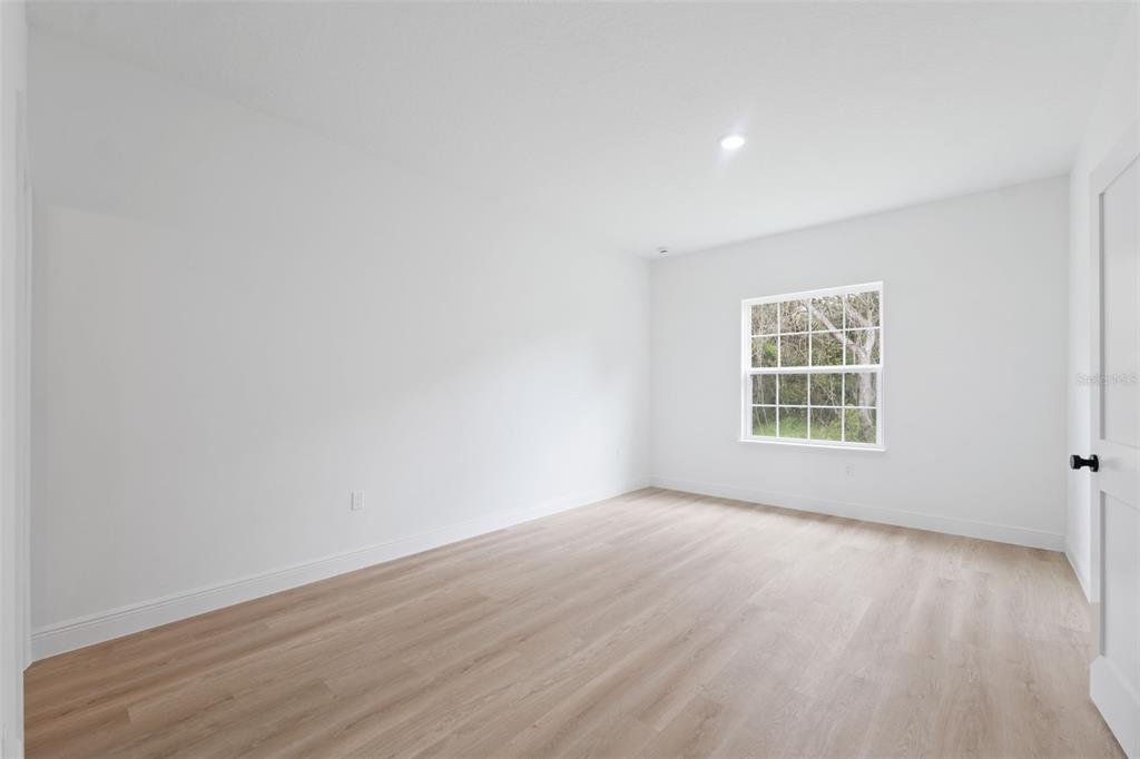 15775 Southwest 46th Circle Ocala, FL 34473 - Photo 18 of 35 an empty room with wooden floor and windows