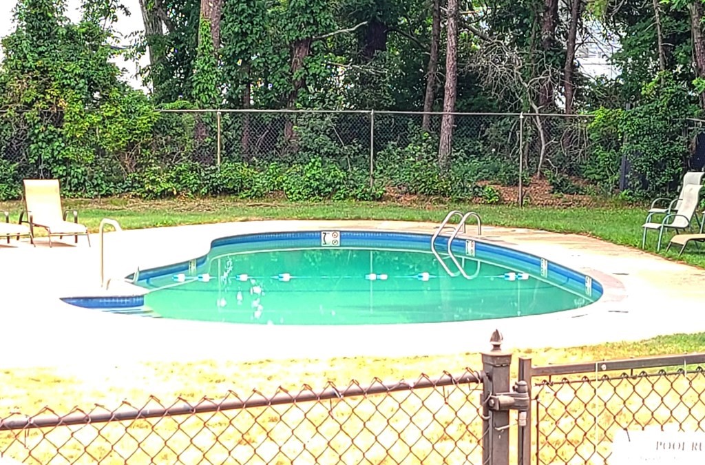 174 Lowell Road, Unit 62 Mashpee, MA 02649 - Photo 13 of 30 a view of a swimming pool with a yard