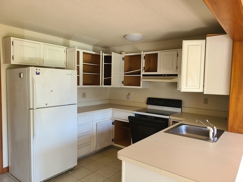 174 Lowell Road, Unit 62 Mashpee, MA 02649 - Photo 18 of 30 a kitchen with a refrigerator sink and cabinets
