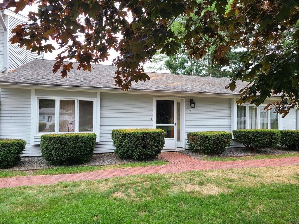 174 Lowell Road, Unit 62 Mashpee, MA 02649 - Photo 29 of 30 a front view of a house with a yard and garage