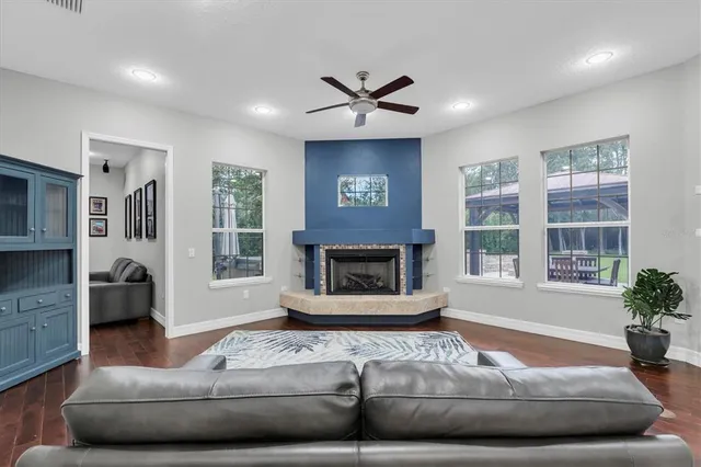 a view of an empty room with a window and chandelier fan