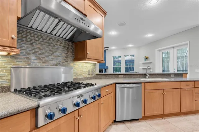 a kitchen with kitchen island a large counter top space appliances and cabinets