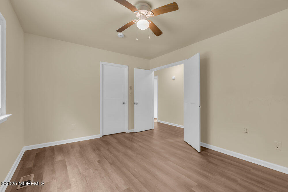 32 Pine Tree Drive Bayville, NJ 08721 - Photo 13 of 63 an empty room with wooden floor a ceiling fan and closet