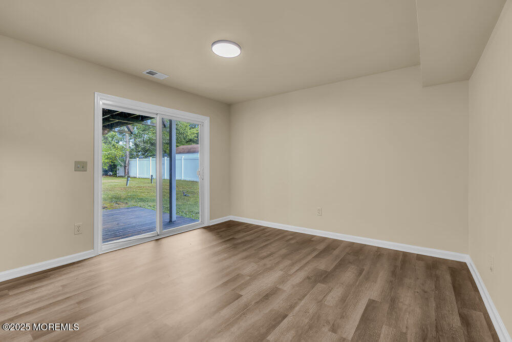 32 Pine Tree Drive Bayville, NJ 08721 - Photo 30 of 63 a view of an empty room with wooden floor and a window