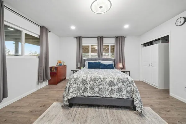 a bedroom with a bed and wooden floor