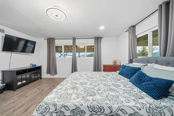 a bathroom with a granite countertop sink and mirror with bathtub