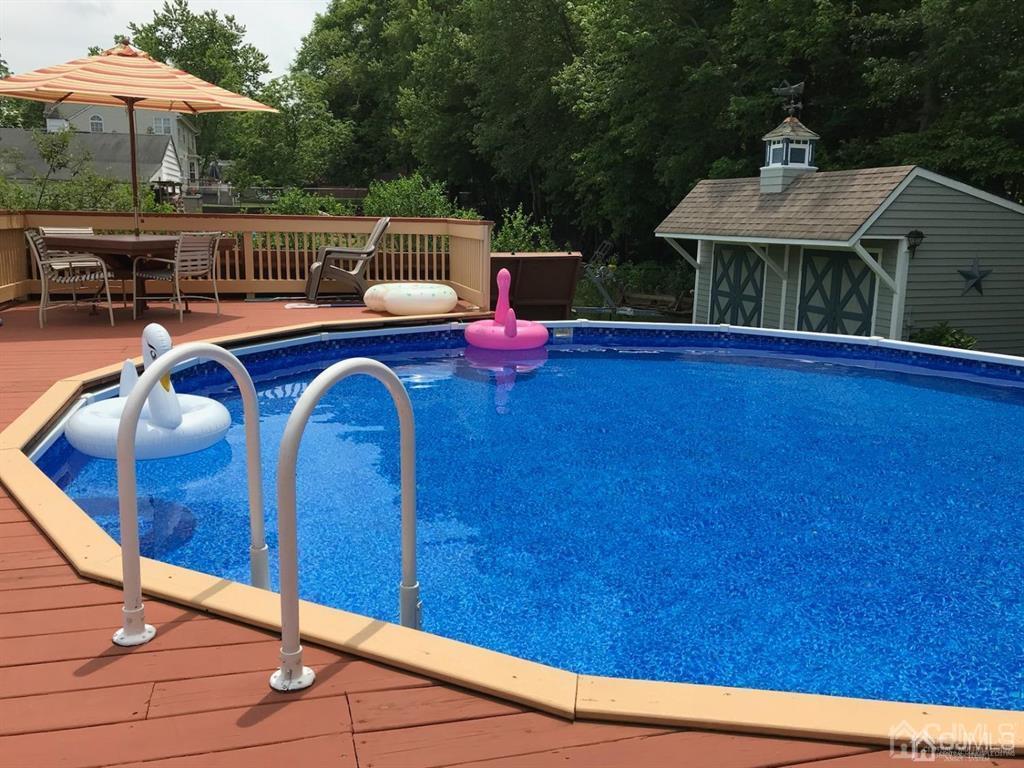 10 Bennett Road Old Bridge, NJ 07747 - Photo 30 of 35 a backyard of a house with table and chairs under an umbrella