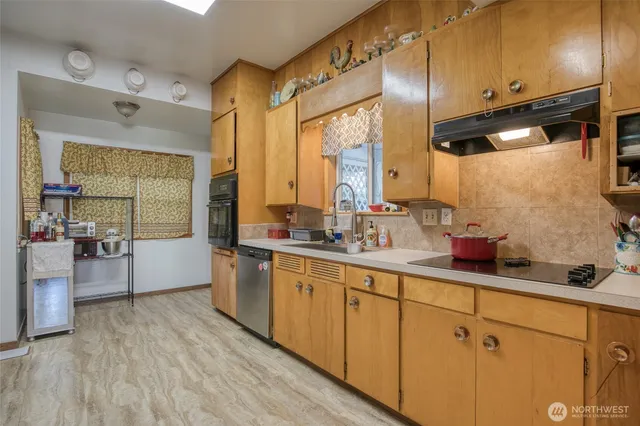 a large kitchen with lot of counter space and wooden floor