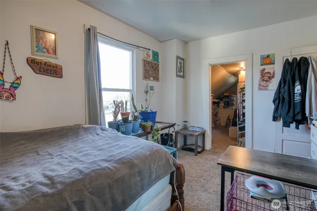 a bedroom with bed a mirror and a window