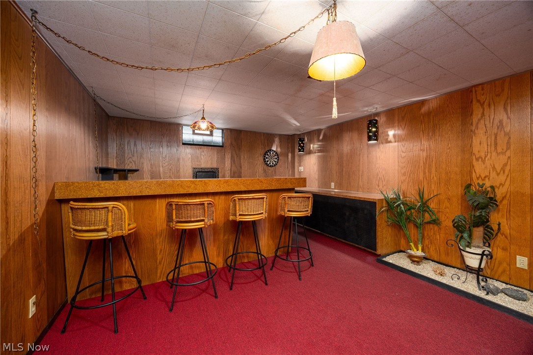 364 Mowbray Road Akron, OH 44333 - Photo 30 of 44 Rec room bar with dark carpet, wood finish cabinets, and wood walls