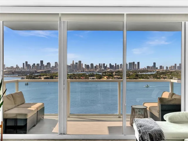 a living room with furniture a flat screen tv and floor to ceiling window