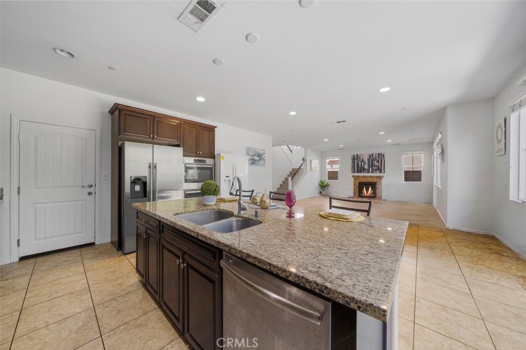 12936 Canopy Court Rancho Cucamonga, CA 91739 - Photo 11 of 30 a kitchen with stainless steel appliances granite countertop a sink and a refrigerator