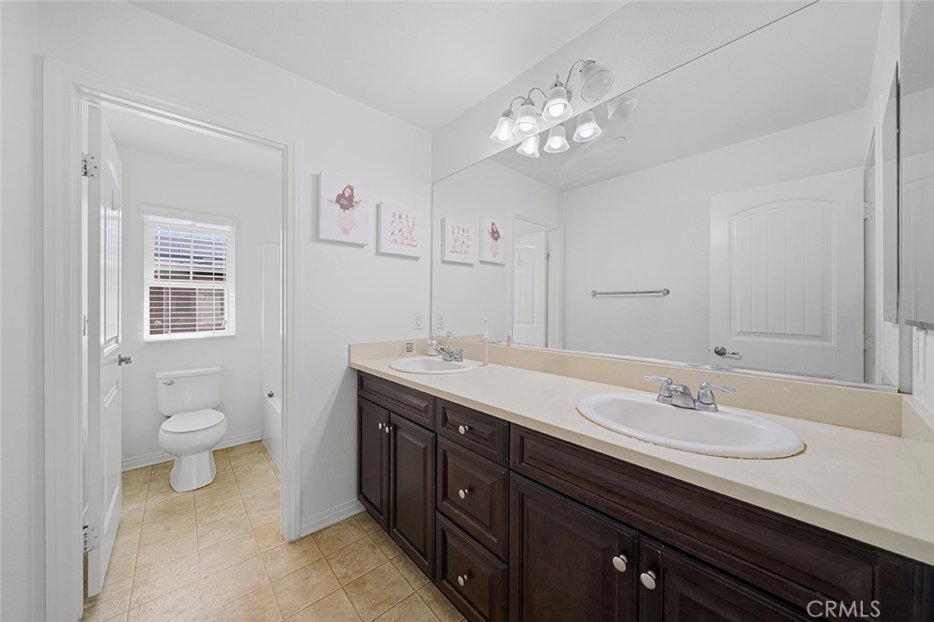12936 Canopy Court Rancho Cucamonga, CA 91739 - Photo 18 of 30 a spacious bathroom with a granite countertop sink a toilet and a mirror