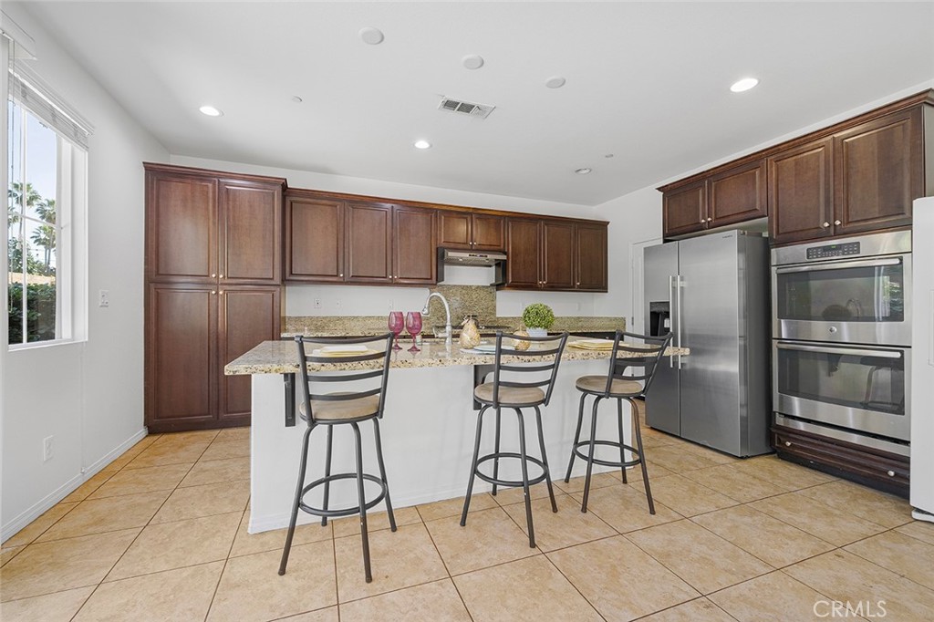 12936 Canopy Court Rancho Cucamonga, CA 91739 - Photo 9 of 30 a kitchen with stainless steel appliances a refrigerator and a stove top oven