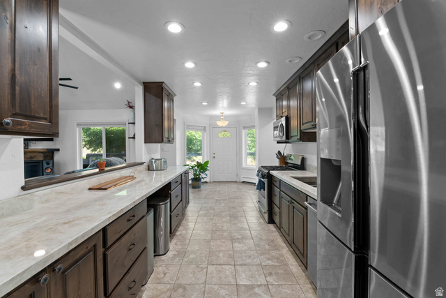 10686 South Covered Brg Cyn Road, Unit 14 Spanish Fork, UT 84660 - Photo 32 of 44 Modern kitchen featuring dark wood cabinetry, light-toned countertops, and stainless steel appliances