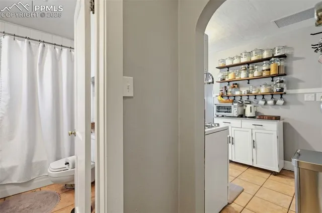 a kitchen with white cabinets and sink