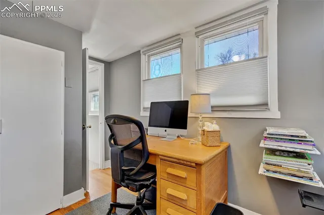 a view of a workspace with furniture and wooden floor