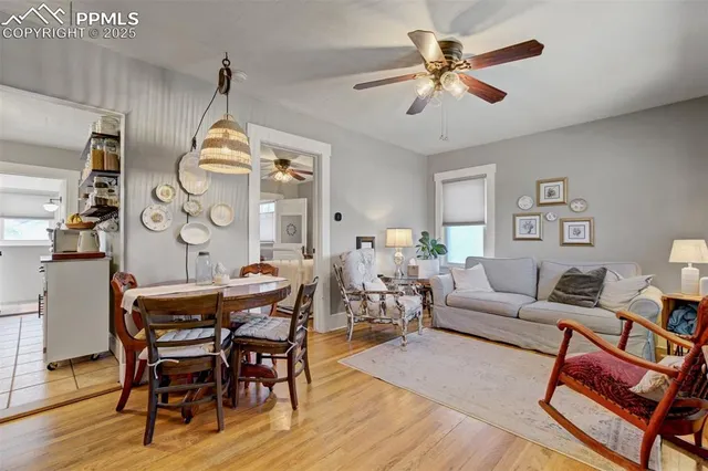 a view of dining room and livingroom with furniture wooden floor a chandelier