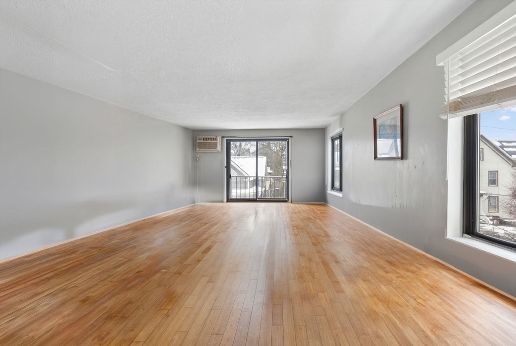 10-16 Stephen Street, Unit 5 Lynn, MA 01902 - Photo 3 of 26 a view of an empty room with wooden floor and a window
