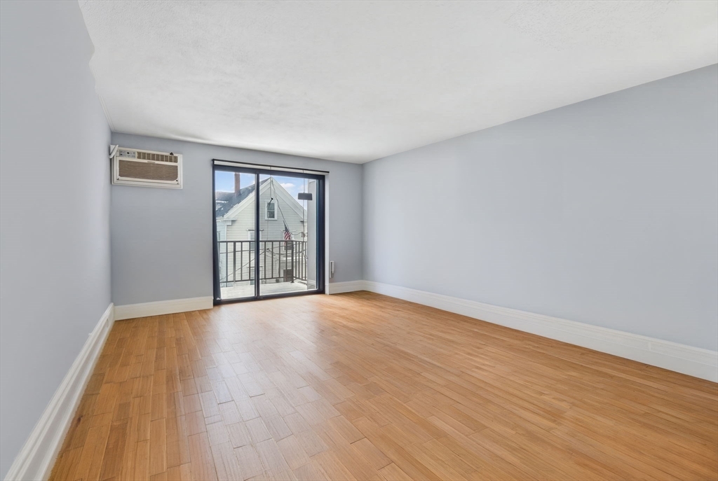 10-16 Stephen Street, Unit 5 Lynn, MA 01902 - Photo 4 of 26 a view of an empty room with wooden floor and a window