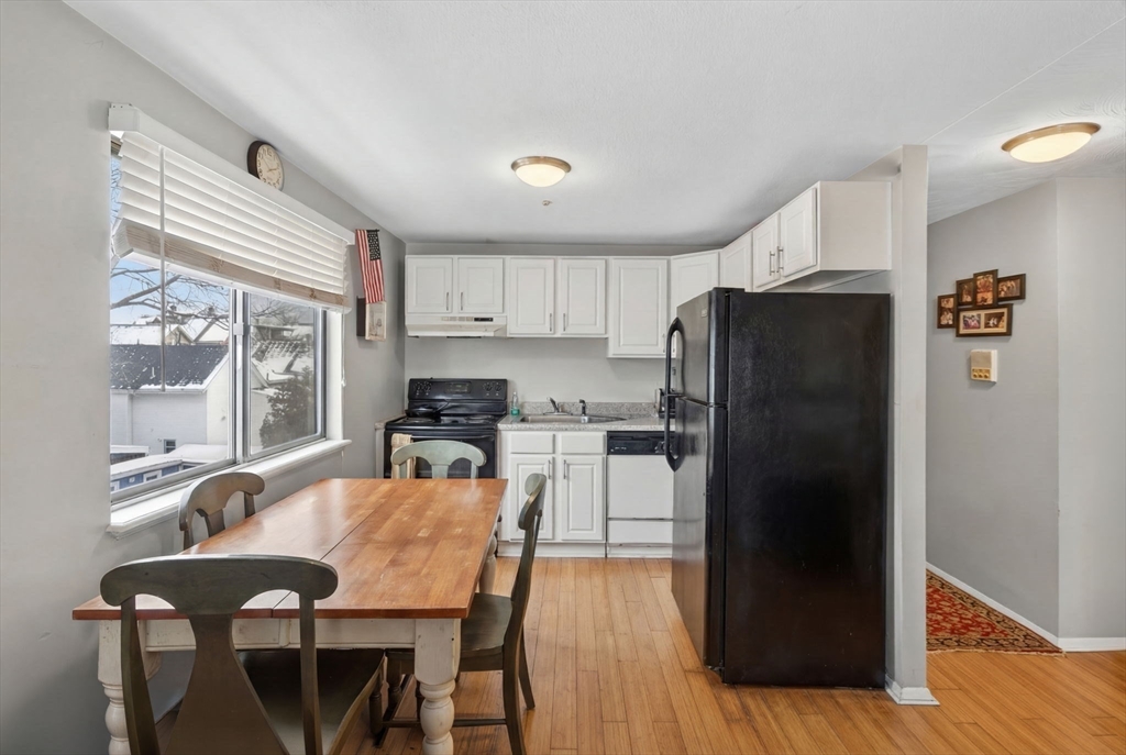 10-16 Stephen Street, Unit 5 Lynn, MA 01902 - Photo 7 of 26 a kitchen with stainless steel appliances granite countertop a refrigerator a sink a stove a dining table and chairs