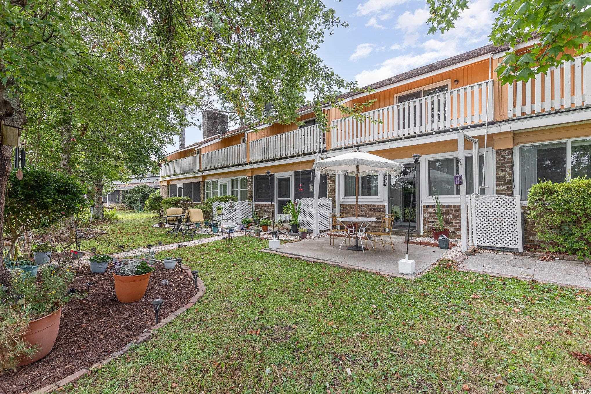1830 Fairway Ridge Drive, Unit 6D Surfside Beach, SC 29575 - Photo 26 of 35 Rear view of property featuring a lawn, a patio ar