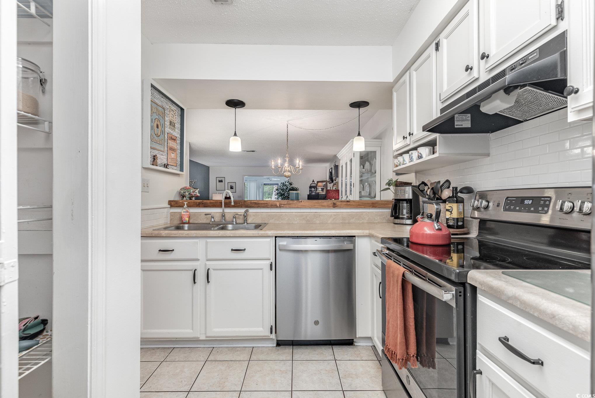 1830 Fairway Ridge Drive, Unit 6D Surfside Beach, SC 29575 - Photo 6 of 35 Kitchen with white cabinetry, decorative light fix