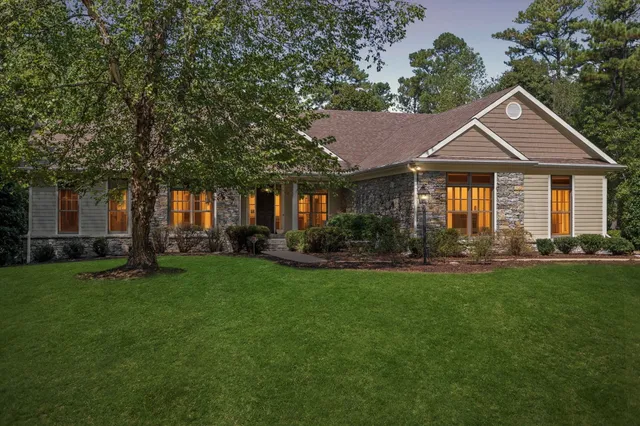 a front view of a house with a yard and trees