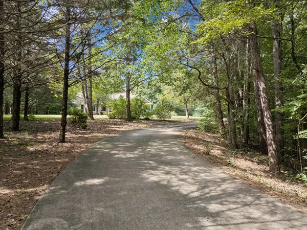 a living room with furniture large window and wooden floor