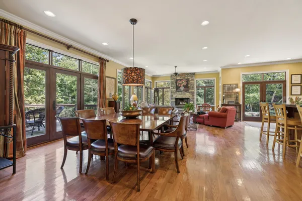 a kitchen with stainless steel appliances a dining table chairs stove and refrigerator