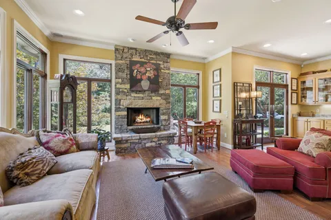 a kitchen with stainless steel appliances granite countertop a stove a sink a oven a dining table and chairs with wooden floor