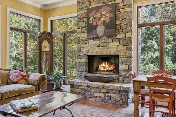 a kitchen with stainless steel appliances granite countertop a stove a sink a oven a dining table and chairs with wooden floor