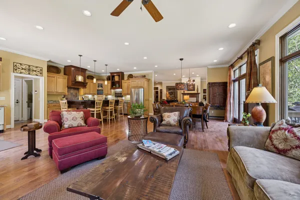 a kitchen with stainless steel appliances a dining table chairs stove and white cabinets
