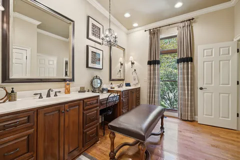 a spacious bedroom with a bed a table and potted plant on the dresser