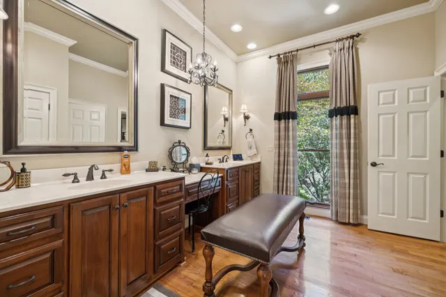 a spacious bedroom with a bed a table and potted plant on the dresser