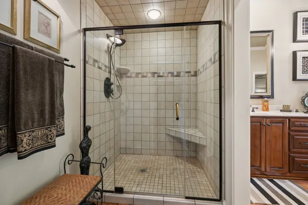 a spacious bedroom with a bed a table and potted plant on the dresser