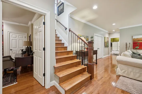 a open kitchen with granite countertop a stove top oven a sink and a wooden floor