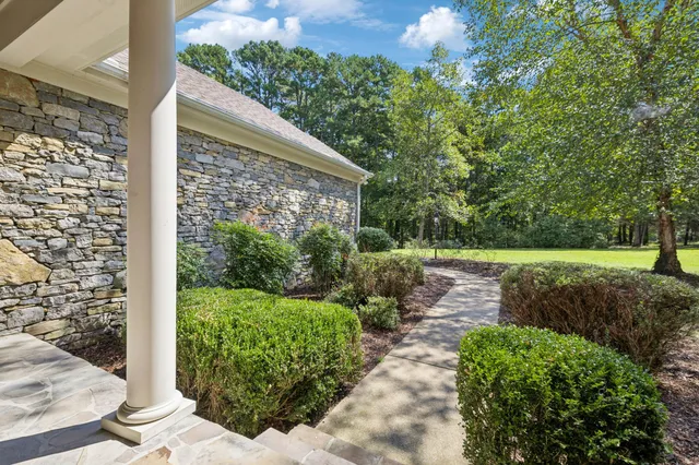 a living room with furniture a chandelier and a bookshelf