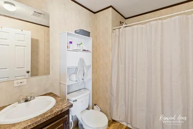 a bathroom with a granite countertop sink toilet and shower