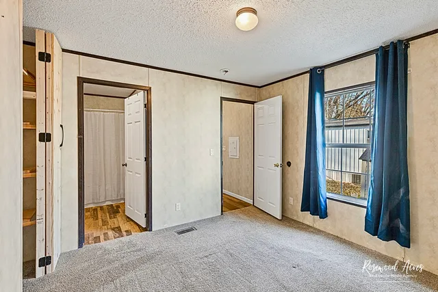 a view of a room with wooden floor and a bathroom