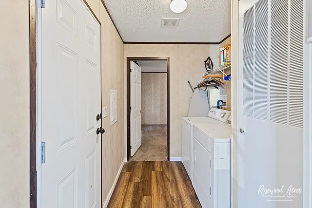 a view of a hallway to a livingroom with furniture and wooden floor