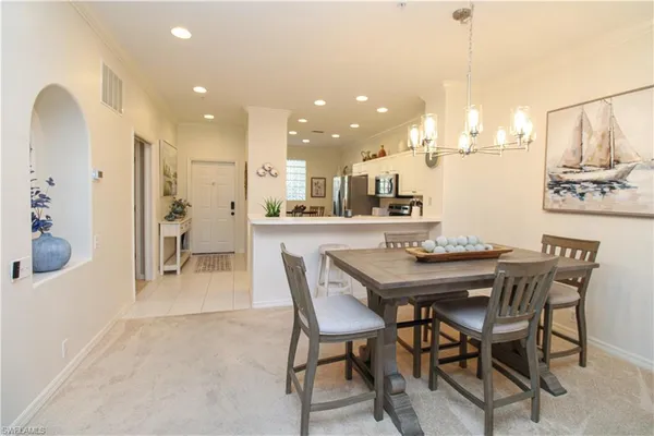 a dining room with stainless steel appliances kitchen island a table and chairs